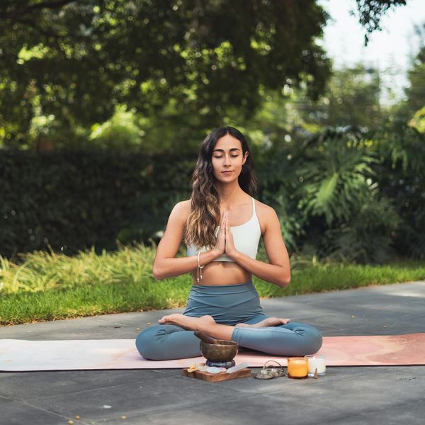 Serene person meditating in a peaceful natural setting.